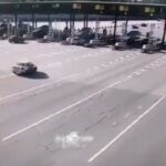 [動画0:14] 高速道路で制御を失った車、料金所に突っ込み横転
