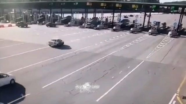 [動画0:14] 高速道路で制御を失った車、料金所に突っ込み横転