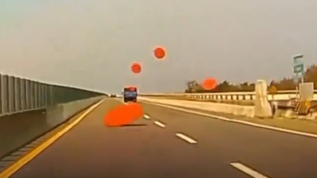 [動画0:34] 高速道路を走行するトラック、次々とテーブルを落としていく