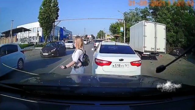[動画0:07] へそ出しスタイルの女性、車の間から道路を横断しようとした結果