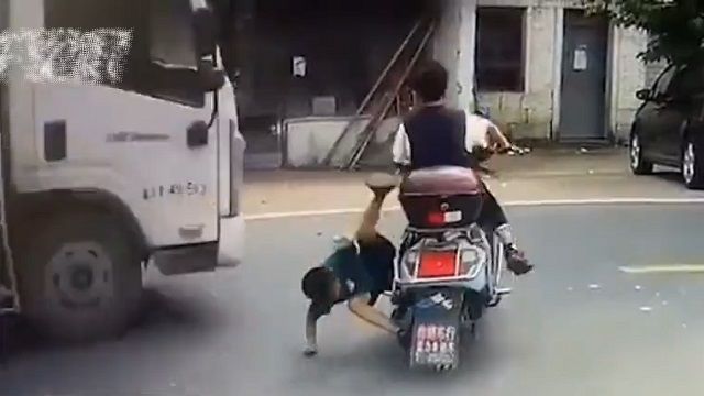 [動画0:25] 子供二人が乗るスクーター、バランスを崩してトラックと接触するが・・・