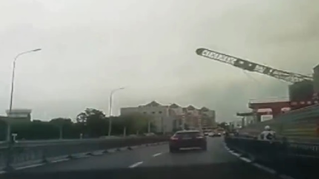 [動画0:50] 重機が倒壊！走行中の車に直撃