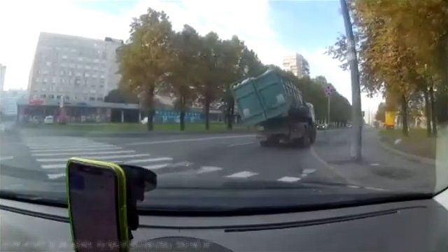 [動画0:21] トラックがカーブで横転、ゴミを撒き散らす