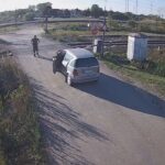 [動画0:55] セルビア人が謎の行動、遮断機の下りた踏切に車を進める
