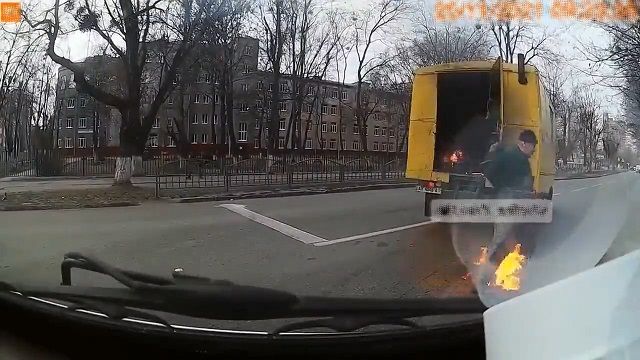 [動画0:21] 走行中のトラックから火のついた男が飛び出す