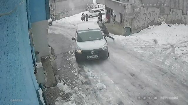 [動画0:29] 凍結した坂道を滑り落ちる車、諦めない男性