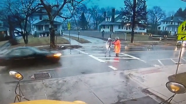 [動画0:25] 横断歩道で誘導する警官、女生徒を守って撥ねられる