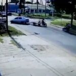[動画0:04] 左折車のトレーラーを避けたバイク、親子の乗るバイクに衝突