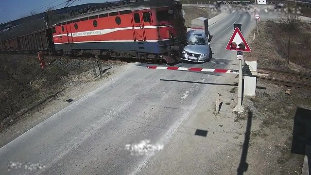 [動画0:22] 遮断機を破壊して踏切に入る車、貨物列車が衝突