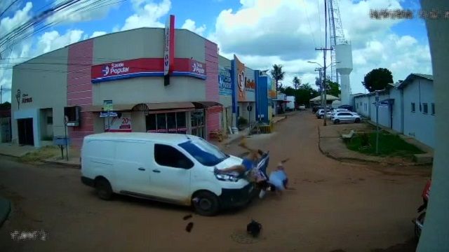 [動画0:15] バイクがバンに衝突、女性がボンネットを乗り越え道路に落下