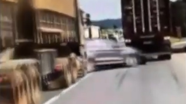 [動画0:45] 強引に車線変更する車、二台のトラックの間で潰される