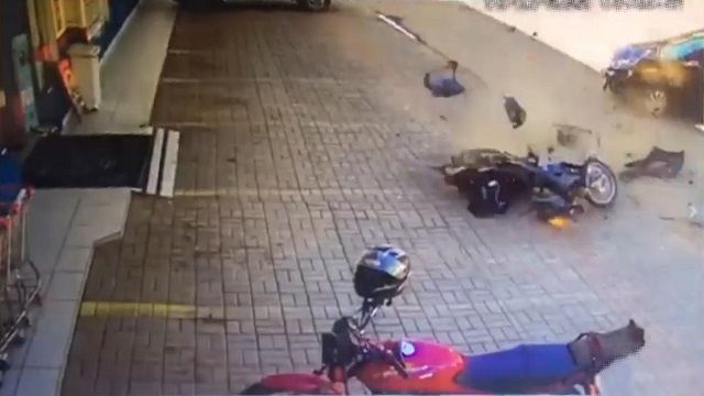 [動画0:48] 駐車場に入ろうとする車にバイクが衝突、吹っ飛んでいく