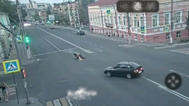 [動画0:10] 左折車に気付いたバイクが転倒、ライダーが車の下に滑り込む