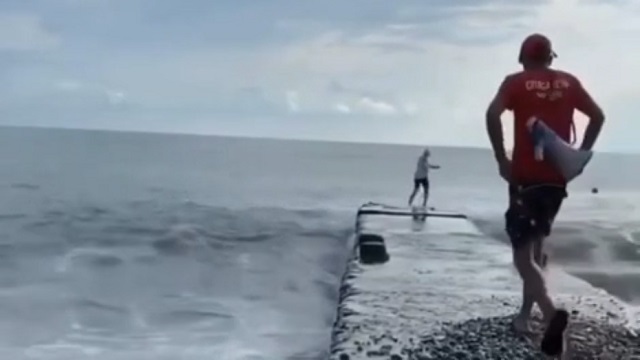 [動画0:52] 荒波の日に桟橋を歩く女性、波にさらわれる