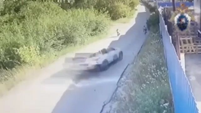 [動画0:24] パトカーが追跡する車、自転車の少年を撥ね飛ばして逃走
