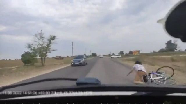 [動画0:26] 自転車の男性が転倒、車道に倒れてしまう