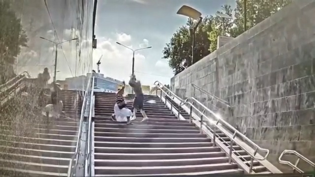 [動画0:10] 地下鉄駅の階段を下る女性、背後から男に襲われる