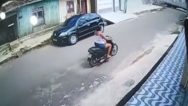 [動画0:15] バイクに乗る女性の頭に電柱直撃！？