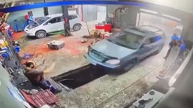 [動画0:34] 自動車整備工場を訪れた女性、整備士の両足を潰す
