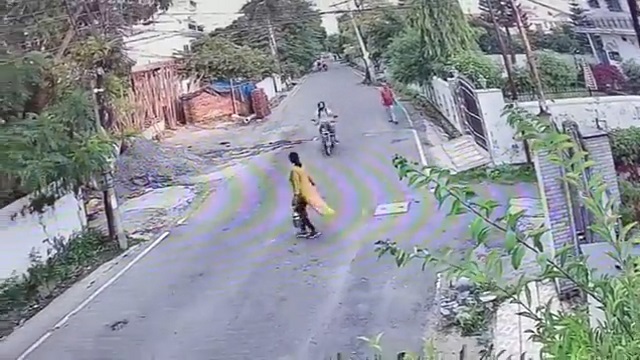 [動画0:09] よく確認せずに道路を横断する女性、バイクの直撃をくらう