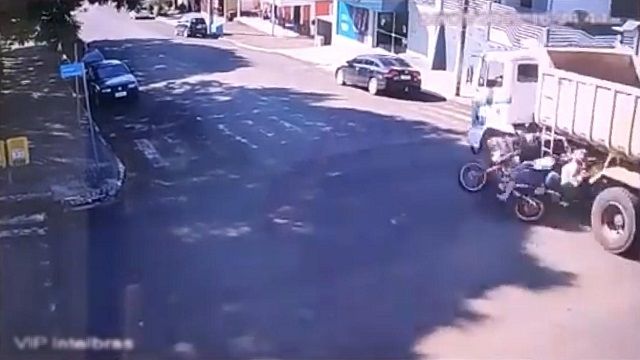 [動画0:20] バイクがダンプに衝突、後輪に巻き込まれた？？！！