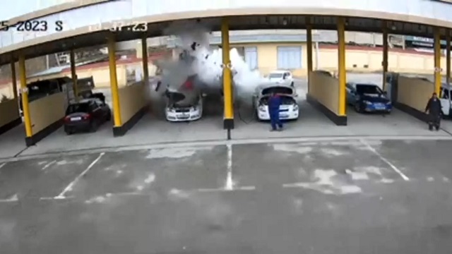 [動画0:26] 車が大爆発、ガスボンベが従業員に直撃してしまう
