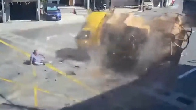 [動画0:18] 下りカーブでトラック横転、ドライバーが車外に投げ出される