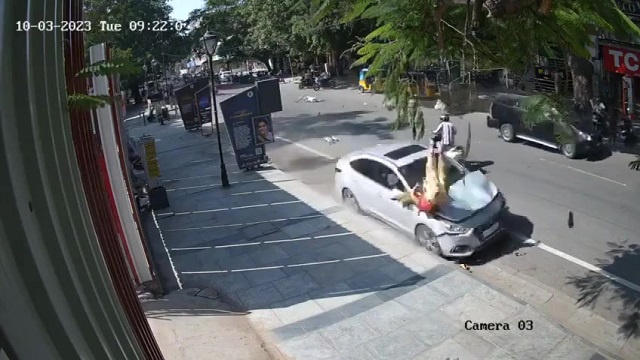 [動画0:15] 事故に気付いた女性、振り向いた瞬間に飛んでいく