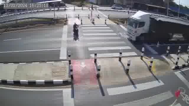 [動画0:15] スクーターの女性、横断歩道を渡ってセミトレーラーにはねられる