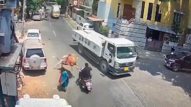 [動画0:19] 雄牛に襲われたスクーター男性、走行中のトラックの下に投げ出される