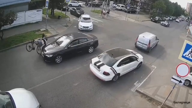 [動画0:14] チャリさん、車列の間から道路を横断しようとして車にはねられる
