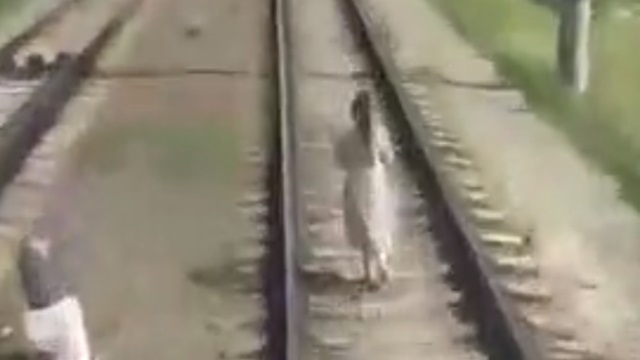 [動画0:23] 15歳の少女、ヘッドホンをして線路を歩く