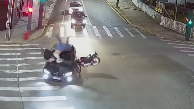 [動画0:41] バイク便が信号無視BMWに衝突、一回転して道路に叩きつけられる